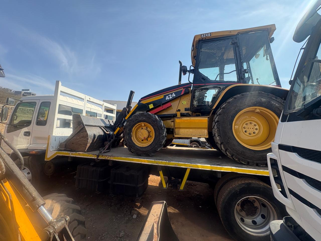 Loading heavy machinery onto flatbed truck